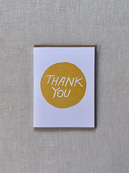 White card with a yellow circle in the middle and white text in the middle reading "Thank You"