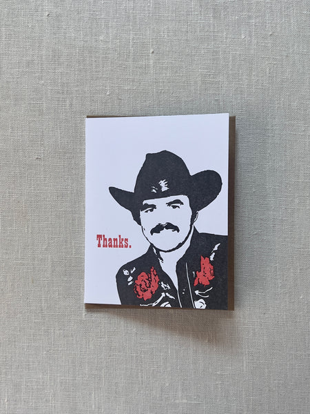 man in a cowboy hat printed on a white card with red text next to him reading "thanks"