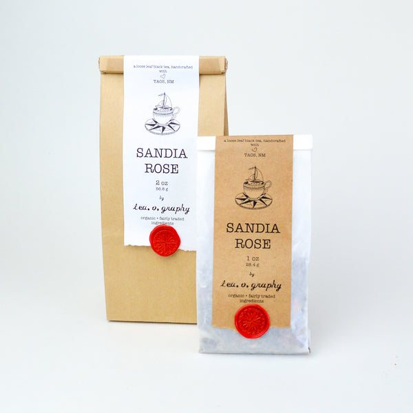 medium Brown paper Bag  and a small white with a white and brown label respectively, held down by a red wax seal. both labels have black text reading "Sandia Rose"