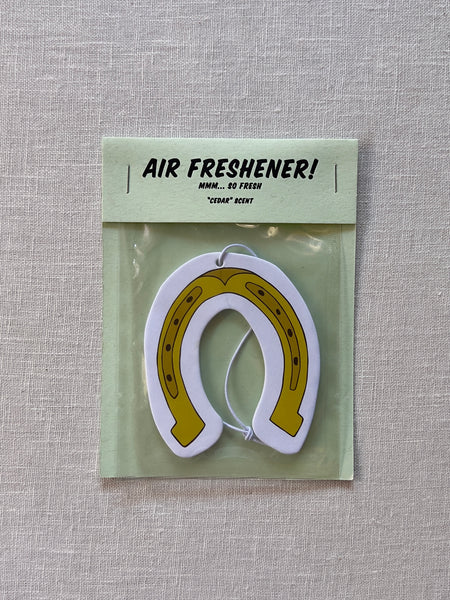 Air freshener shaped like a horseshoe in gold