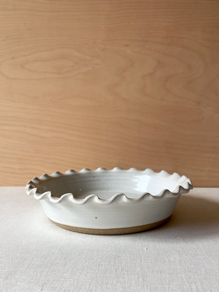 White speckled ceramic pie dish with a tan ring at the bottom.