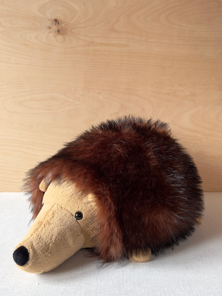 Large stuffed hedgehog with fluffy hair on his body and a smooth face.
