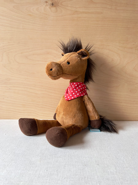 Stuffed brown horse with a red and white polkadot bandanna.