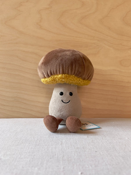 Brown mushroom plushie with a smile and tiny feet