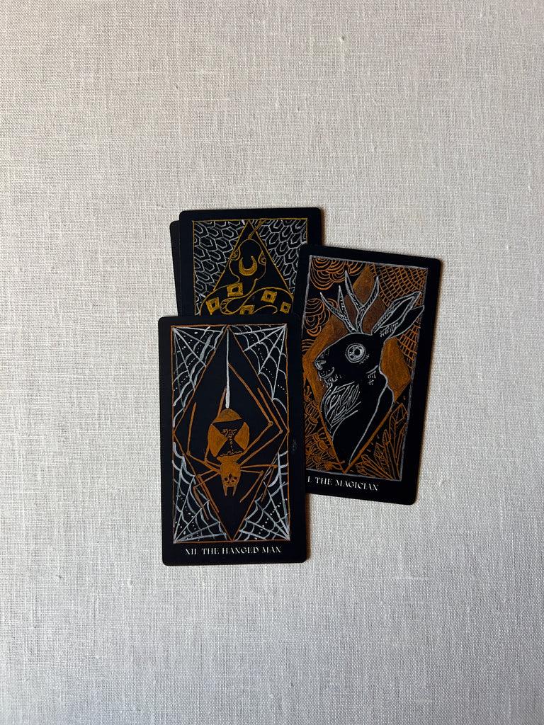 Three stylized tarot cards bunched together