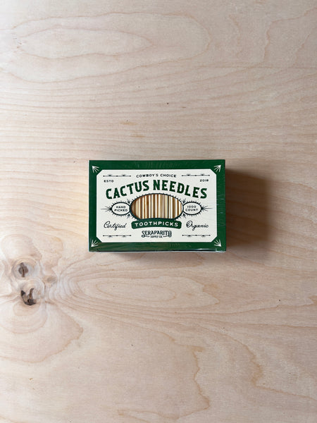 Rectangular green and white paper box with green text that reads "Cactus needles toothpicks."