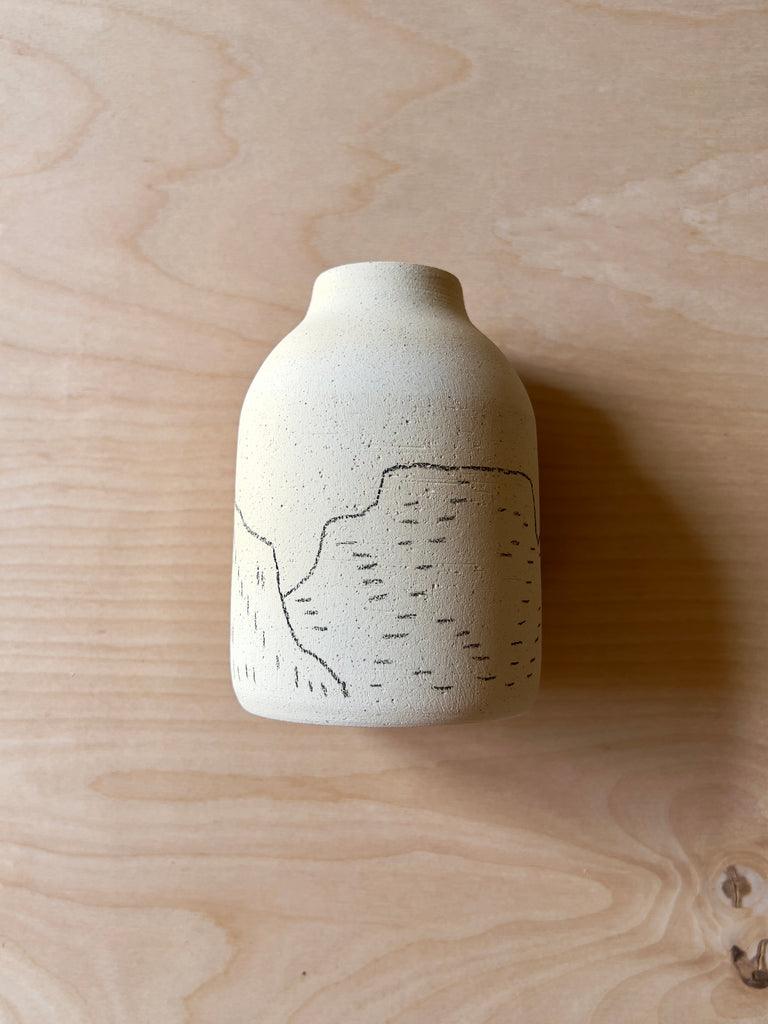 mini white ceramic jug with black outline of mountains.