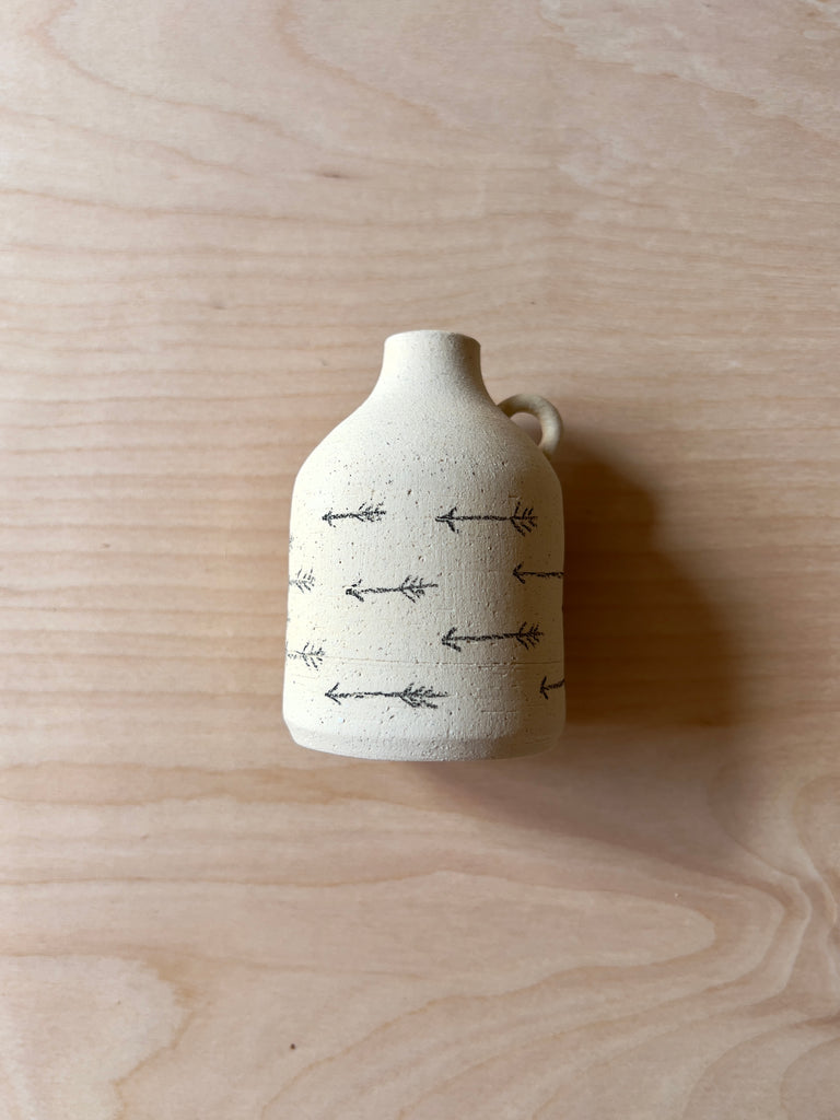 mini white ceramic jug with multiple black arrows.