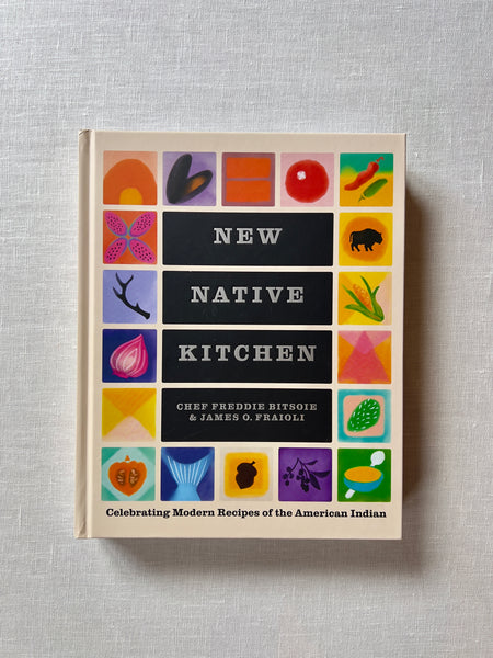A cover of the book "New Native Kitchen" by Chef Freddie Bitsoie & James O. Fraioli. The cover has various colorful illustrations of food images and symbols. Additional text reads "New Native Kitchen: Celebrating Modern Recipes of the American Indian."