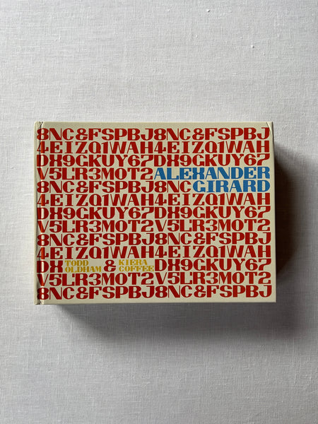 A Cover of the book "Alexander Girard" by Todd Oldham & Kiera Coffee. The cover has repeated sequences of letters and words in red.
