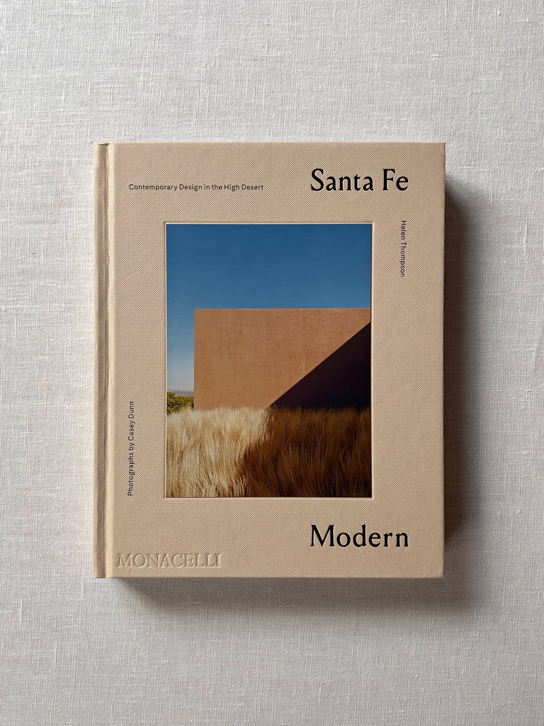 Beige cover of the book "Santa Fe Modern." A pueblo style house and desert landscape are in the middle