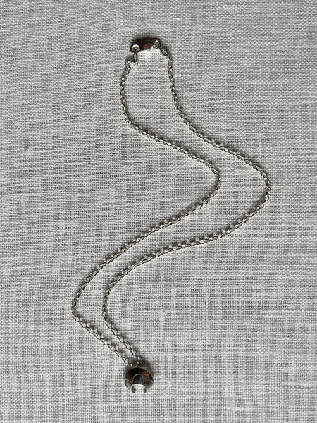 Sterling silver chain link necklace with a small crescent moon pendant.