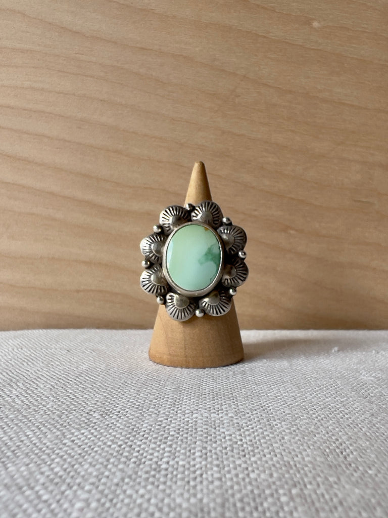 Small circular turquoise ring with flower like sterling silver casting