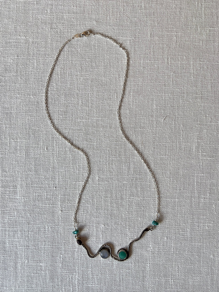 Sterling silver snake  necklace with wire wrapped turquoise and precious stone , the snake future a 6x4 mm precious stone and 8mm round turquoise. The length of the necklaces is approximately 19 inches long .