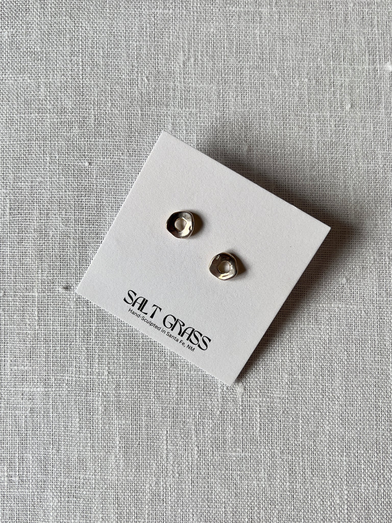 Sterling silver hammered studs with a donut shape.