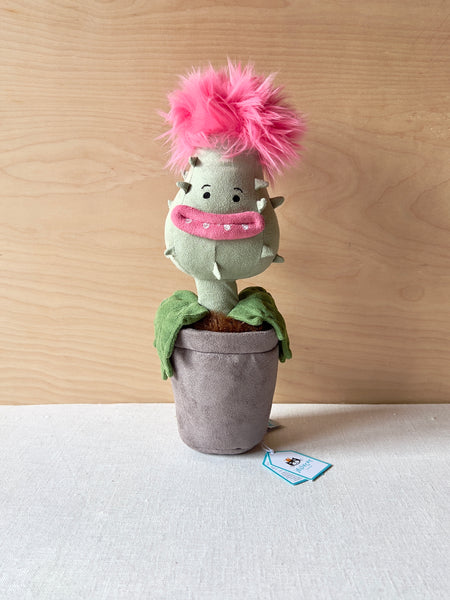 Stuffed potted plant with a toothy smile and fluffy pink hair