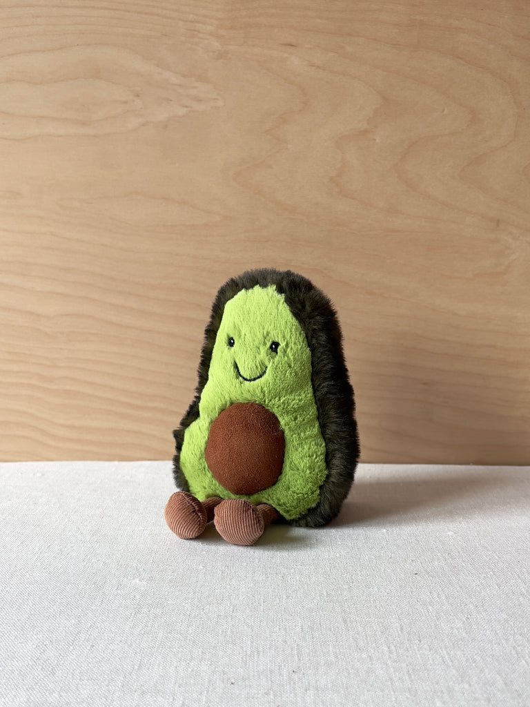 Small stuffed avocado with a happy face and little feet.