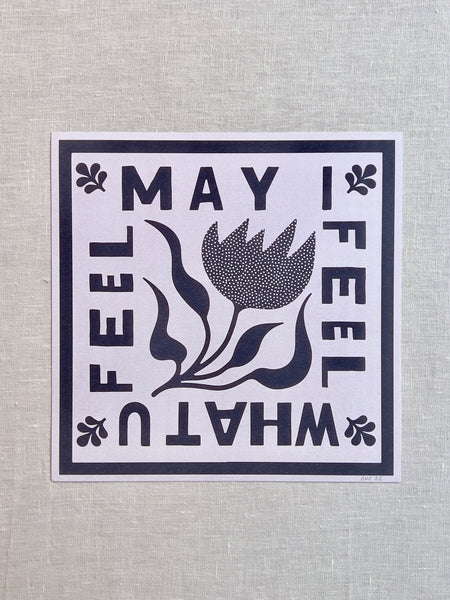 White print with a blue flower in the middle and blue text around it "May I Feel What U Feel"