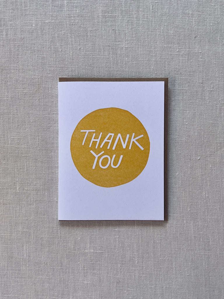 White card with a yellow circle in the middle and white text in the middle reading "Thank You"