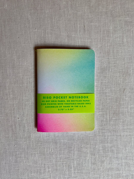 notebook with a gradient of colors green, blue, pink, and yellow.