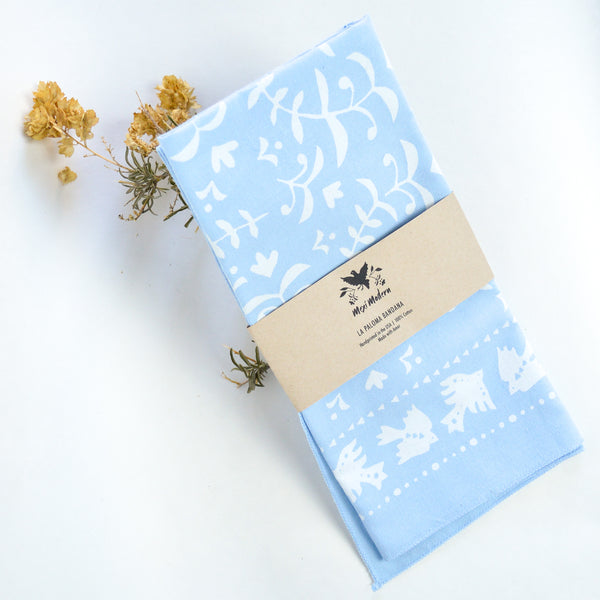 Baby blue and white bandanna with ferns and doves sporadically printed on the bandanna by Mexi Modern.