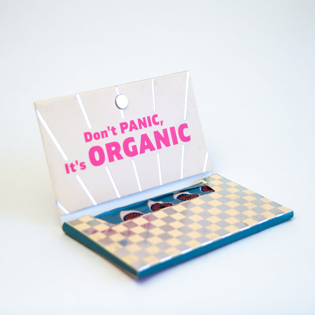 I small cardboard container opened to show its checkered design and pink wording reading "don't panic, it's organic."