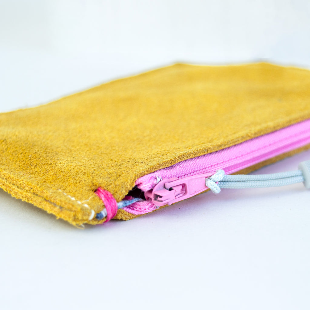 Small yellow leather pouch with a pink zipper and white zipper pull.