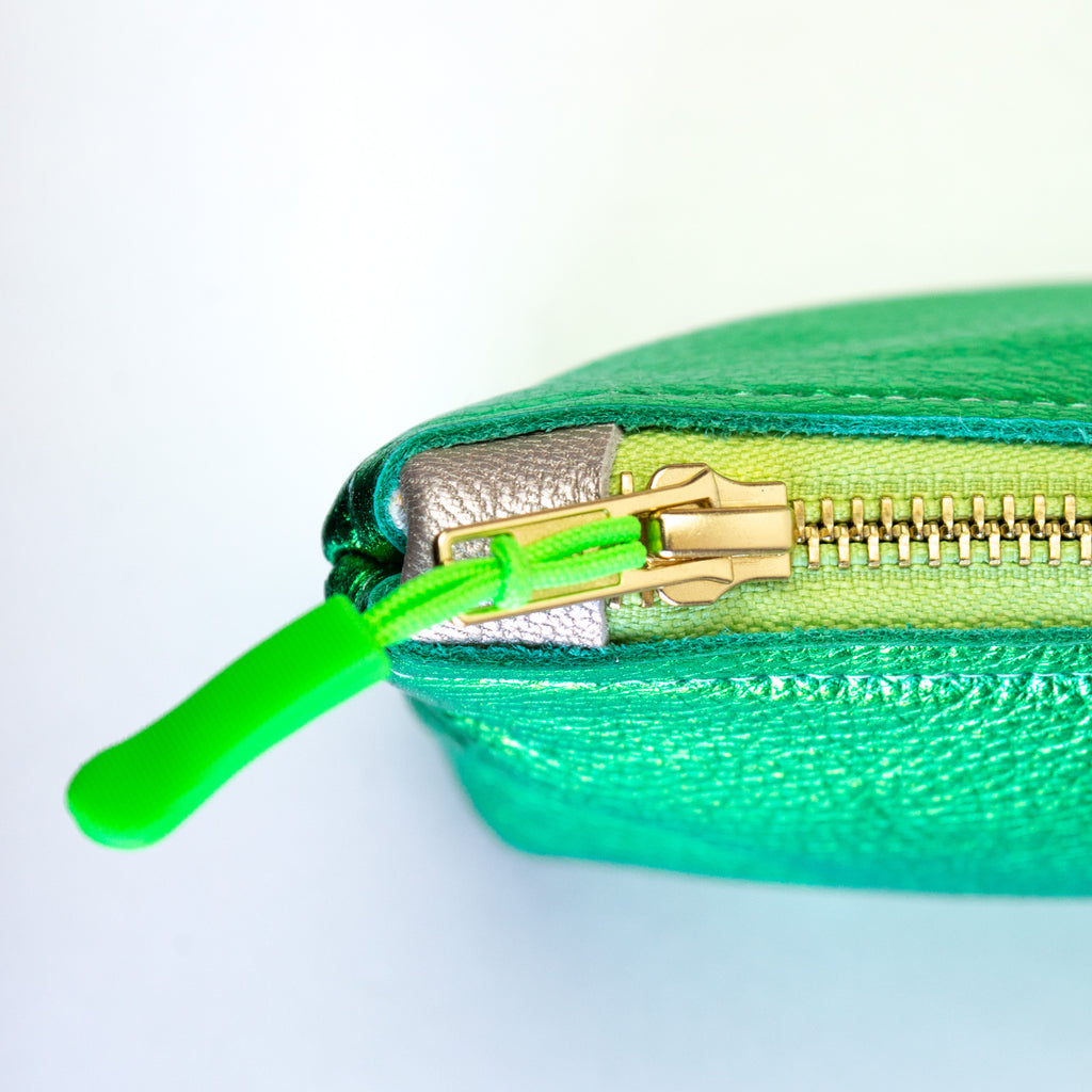 Medium metallic green pouch. Showcasing its gold zipper, green zipper pull, and silver leather zipper catch.