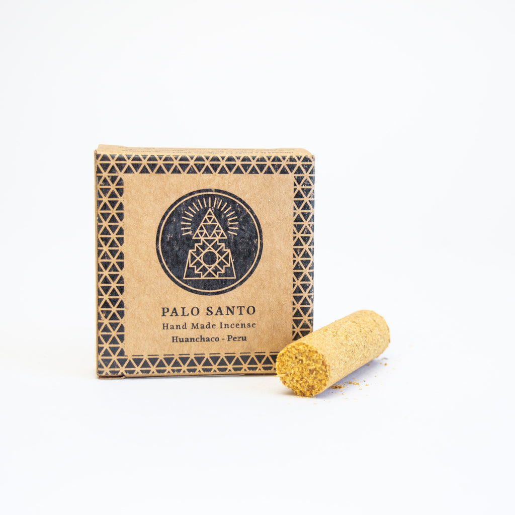 small square box labelled "Palo Santo, hand made incense." There's  a round hand-pressed incense laying next to the box.