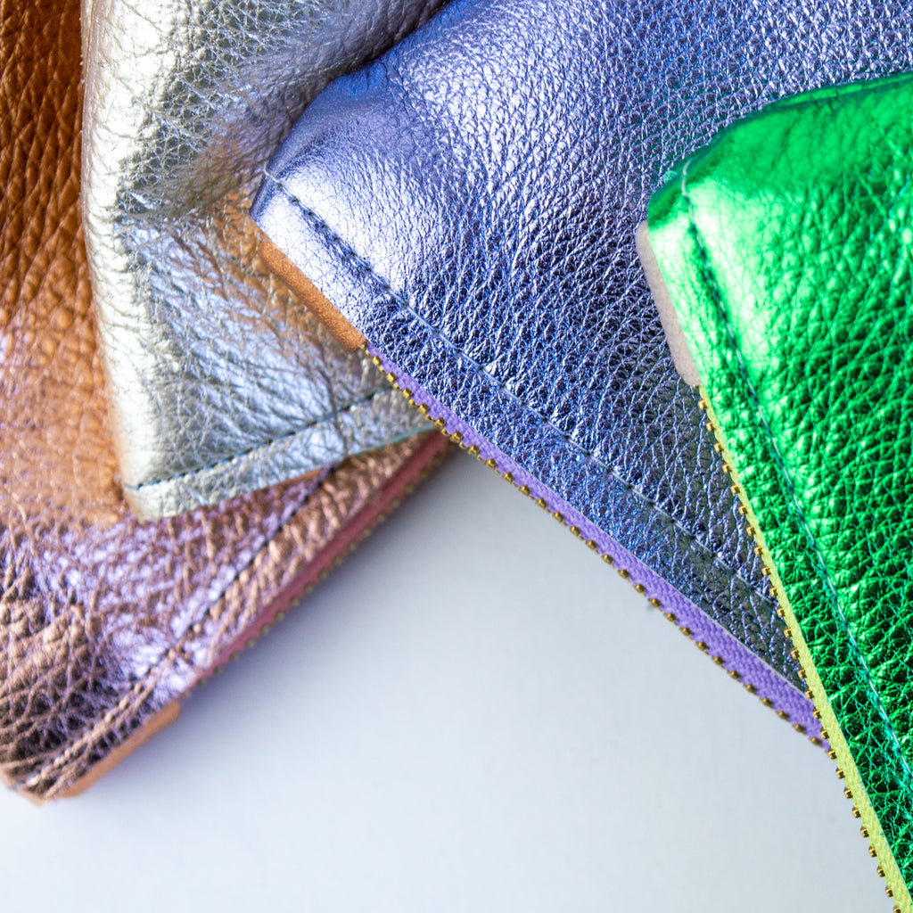 Four medium metallic pouches. From left to right: Pink, silver, purple, and green.