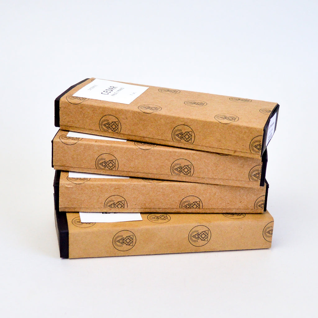 Four small rectangular boxes of incense stacked on top of one another.