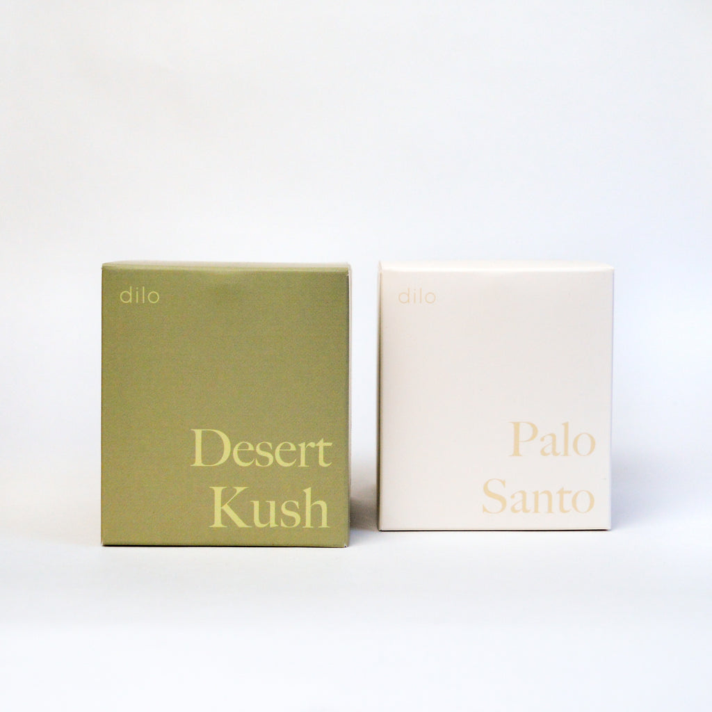 Two small boxes, one green and one white. The green is labelled "Desert kush" and the white is labelled "Palo Santo."