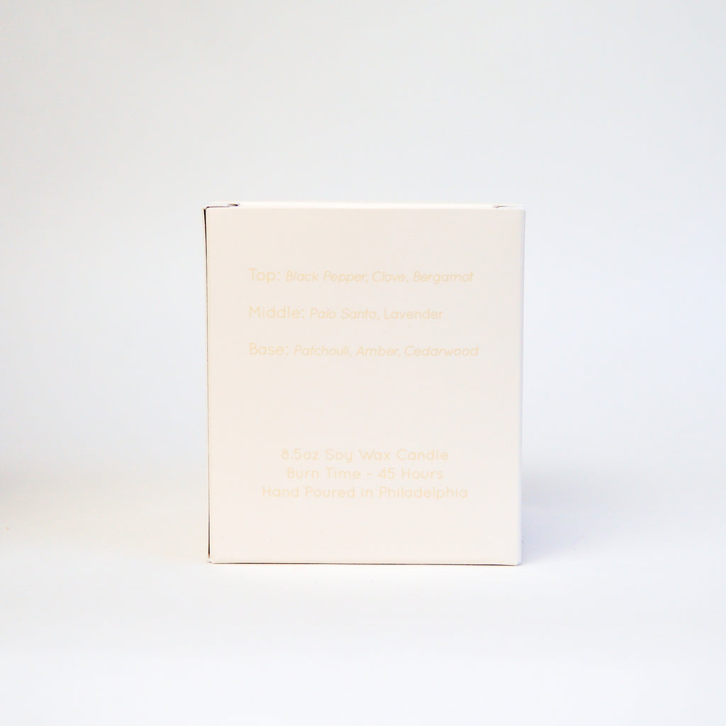 small white box reading with tan text describing the scent notes of a candle.