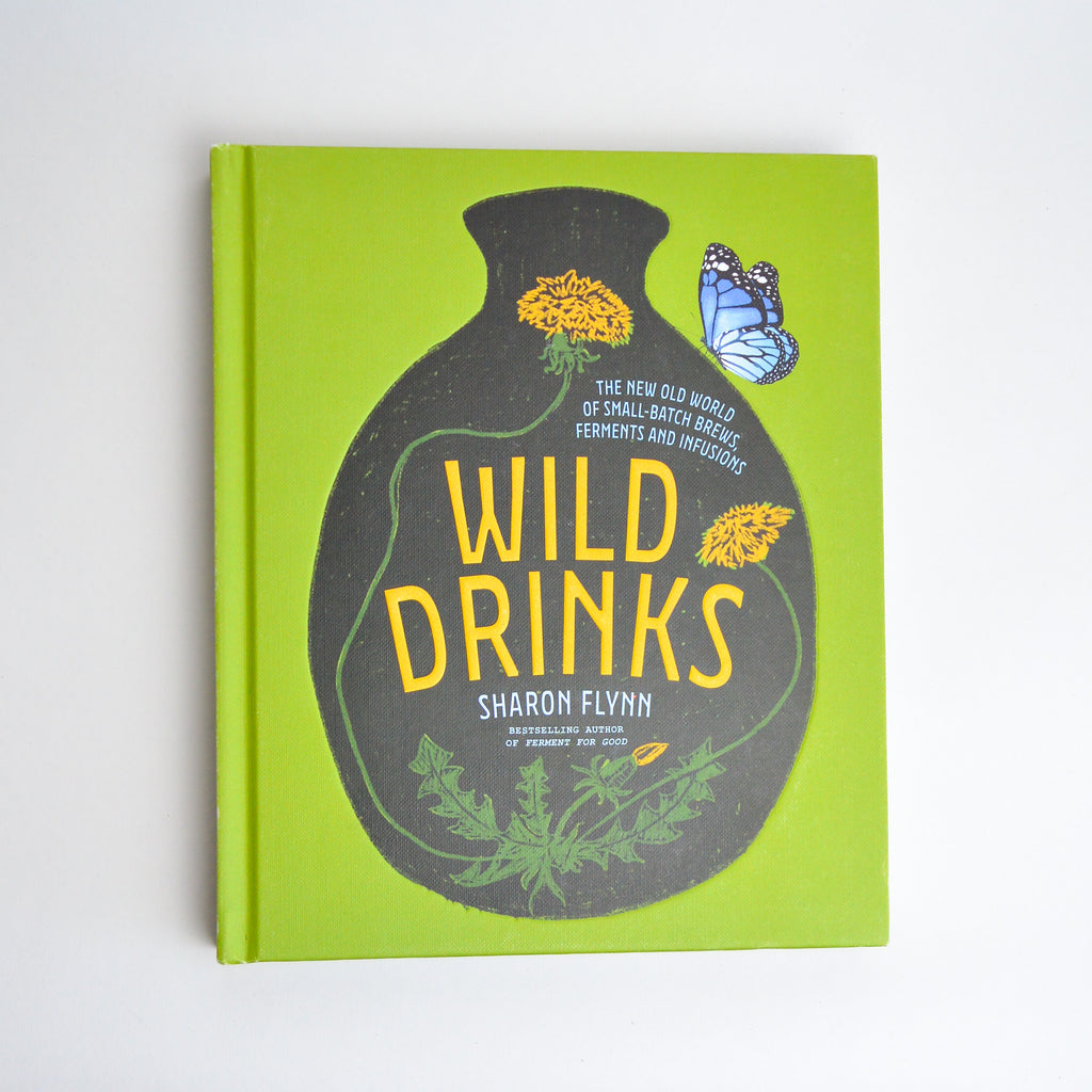 The cover of the book "Wild Drinks" by Sharon Flynn, Bestselling Author of Ferment for Good. The cover is a lime green background with an illustration of a black vase holding dandelions and a blue butterfly. Additional text reads "The New Old World of Small-Batch Brews, Ferments and Infusions."