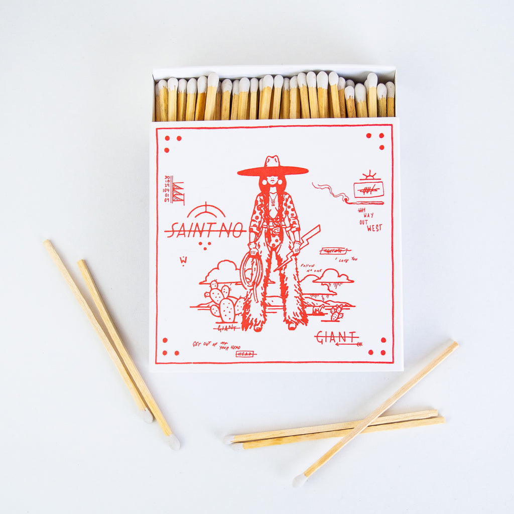An open box of matches with a cowgirl holding a lighting bolt printed on the front.