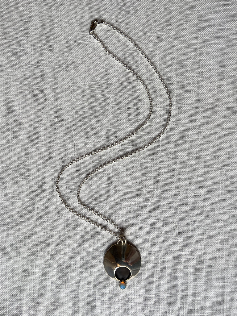 sterling silver necklace with rounded half moon and an onyx droplet.