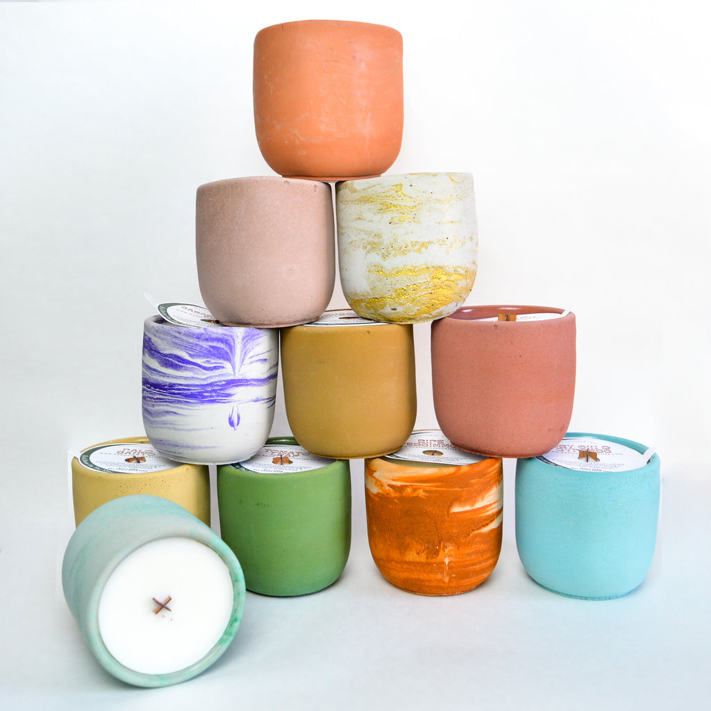 Candles with various vessel colors stacked in a pyramid manner.