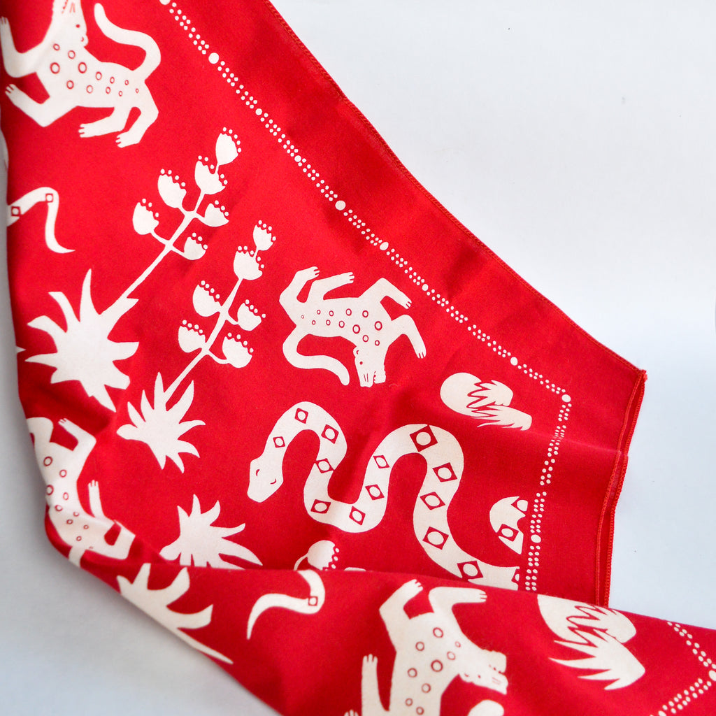 Red and white bandana with various animals and plants printed by Mexi Modern