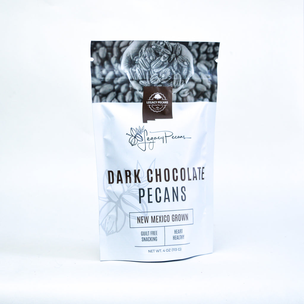 A bag of dark chocolate pecans on a white backdrop.