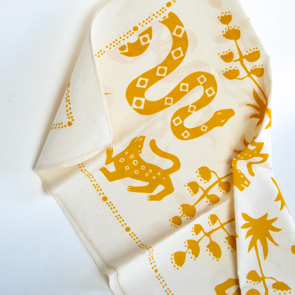 White and yellow bandana with various animals and plants printed by Mexi Modern