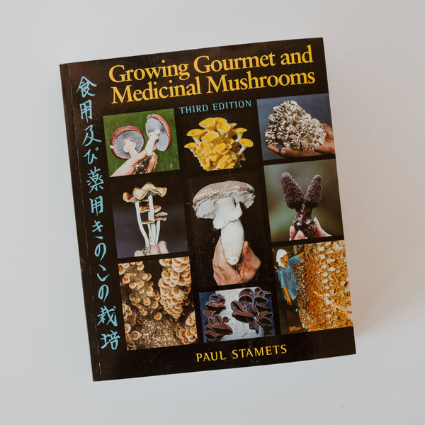 A book called "growing gourmet and medicinal mushrooms" by Paul Stamets. there are multiple images of different  mushrooms on the cover.