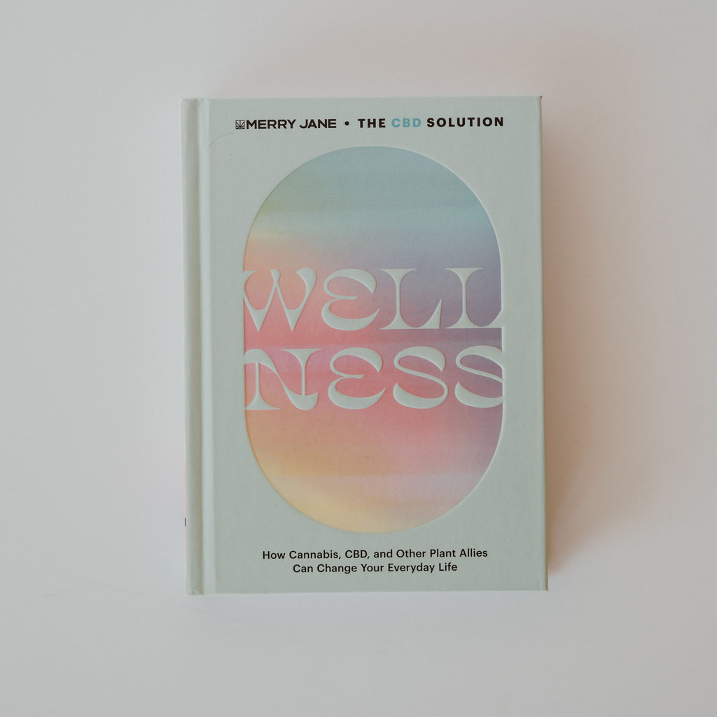 Blue cover of the book "Wellness." The cover has small black text on the top and bottom reading "Merry jane, the CBD solution. How cannabis, CBD, and other plant allies can change your everyday life."