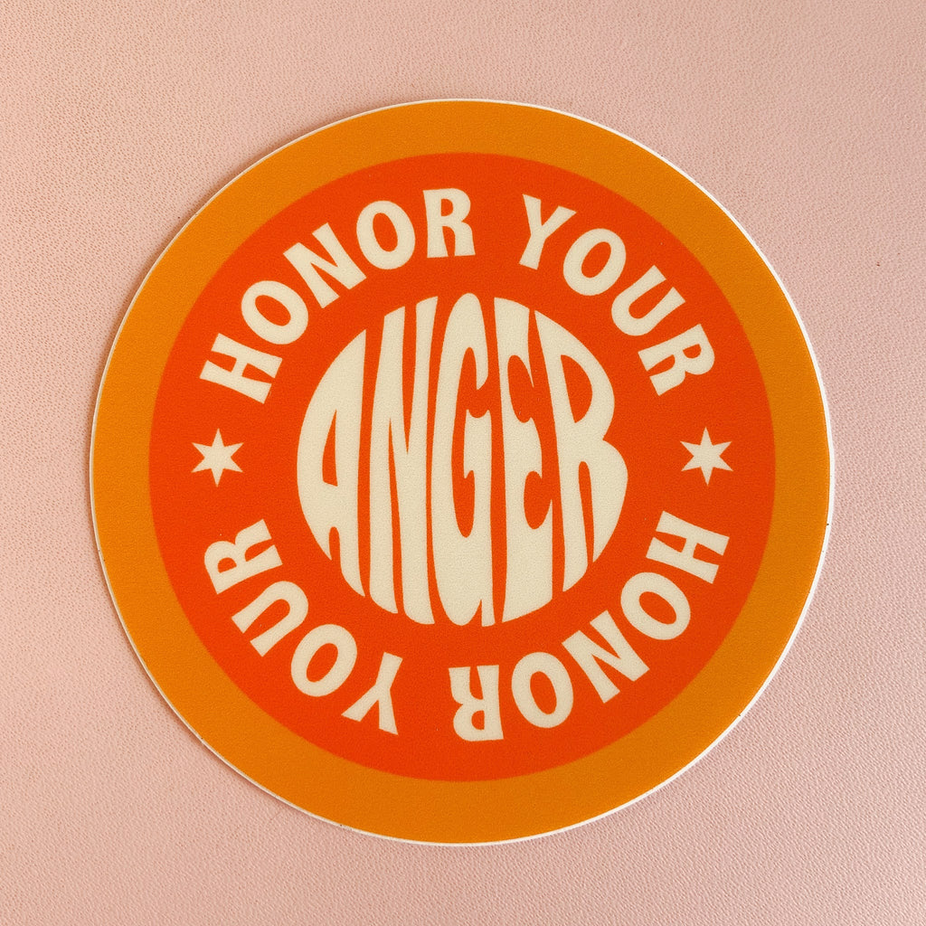 Circular sticker with a light orange boarder and dark orange middle. there's writing that trails from the outside to the middle reading "honor your anger"