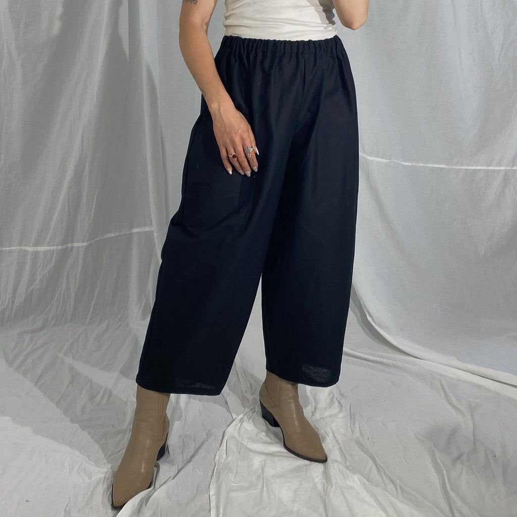 Person wearing a baggy pair of linen like black pants.
