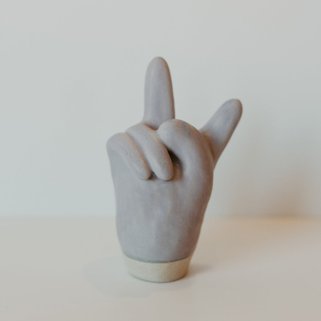 Grey ceramic peace sign hand with a grey band around the bottom.