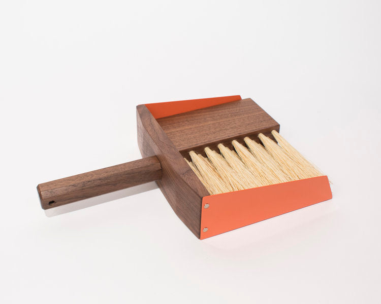 Dark wood hand broom and dustpan with orange metal sides and blonde horse hair bristles.