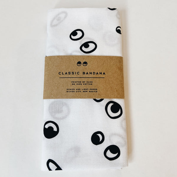A white bandana with pairs of eyeballs printed in black. 