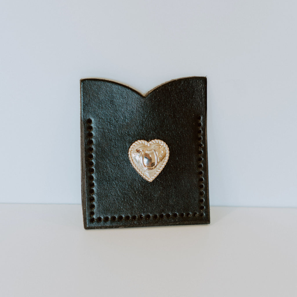 black leather single pocket wallet. there is a silver heart pendant on the front.