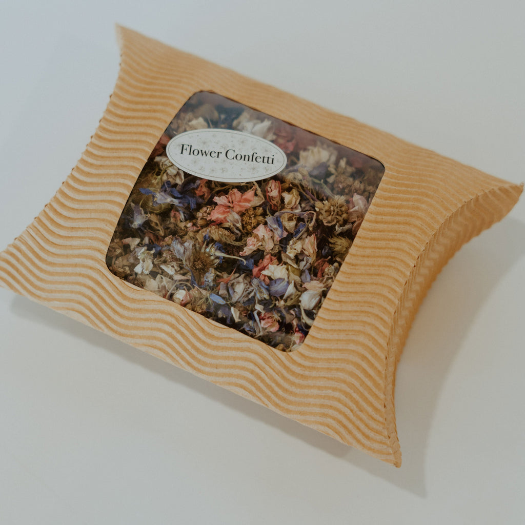 A box filled with a mix of dried wild flowers with a sticker on it that says Flower Confetti.